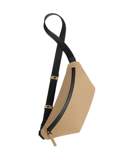 Beige crossbody bag with black strap on a light gray background